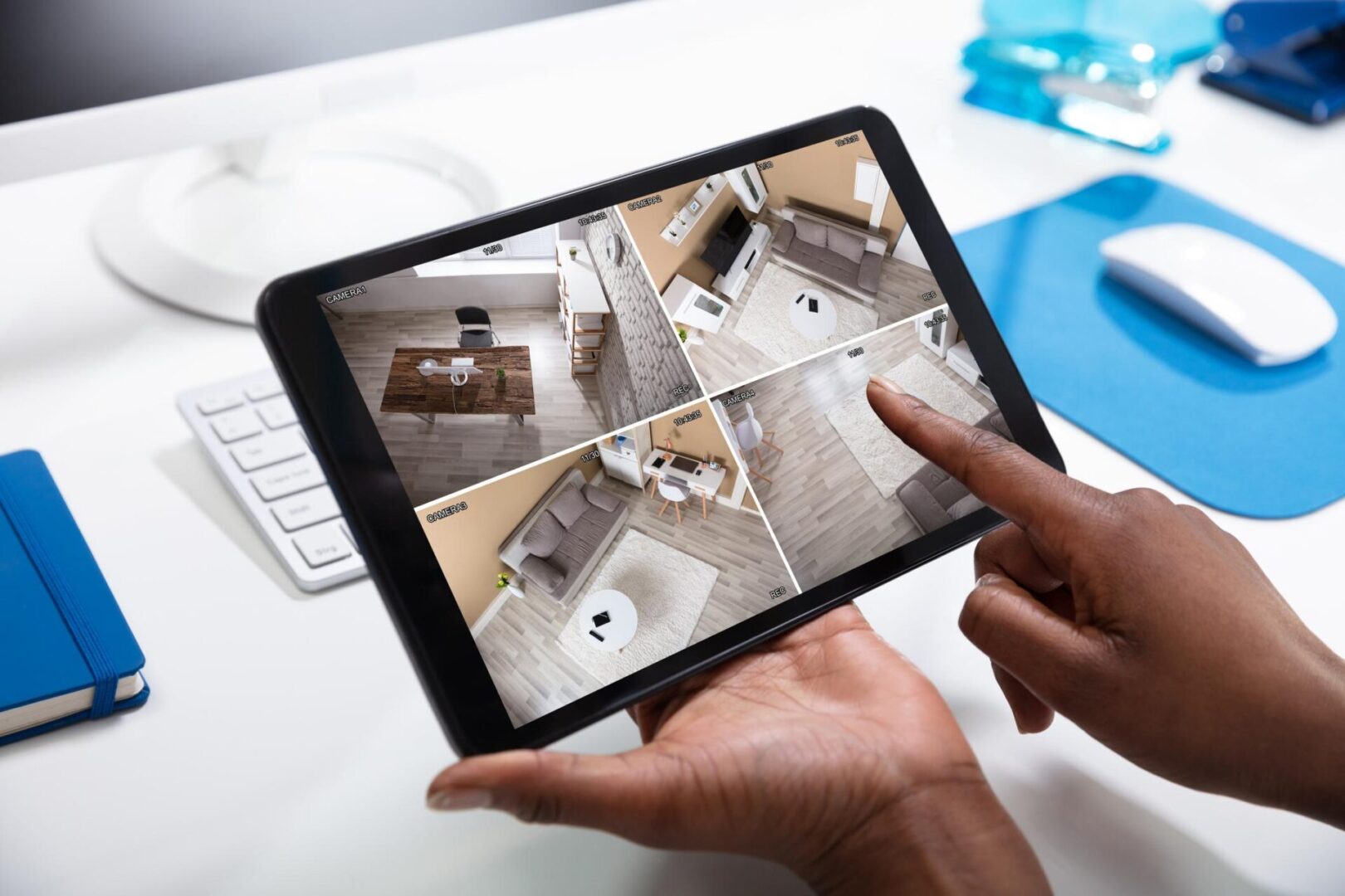 Here's an alt tag for the image: Hands viewing multi-camera security footage.