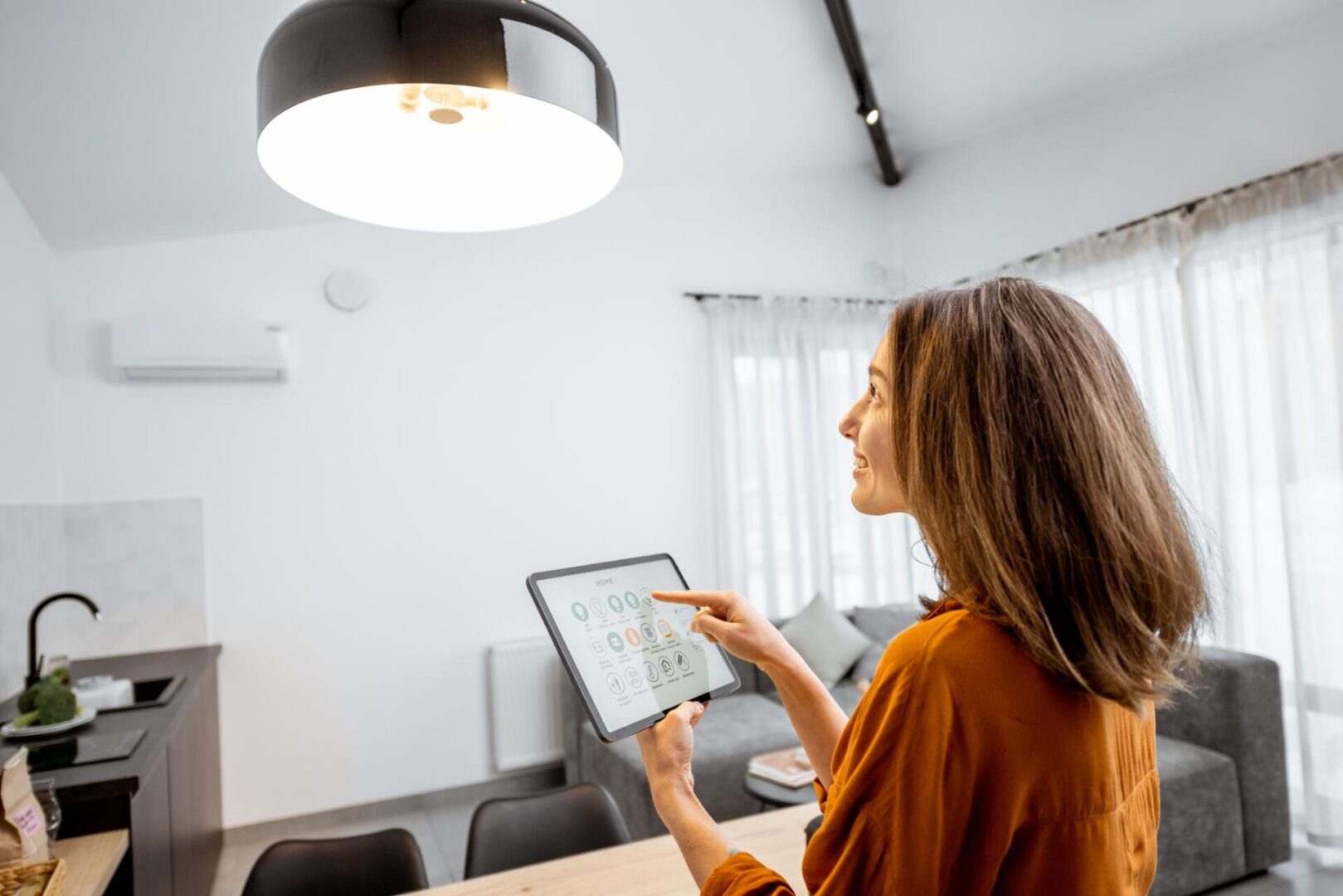 Woman uses tablet to control smart home.